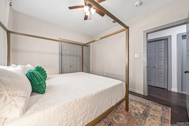 a bedroom with a large bed and wooden floor