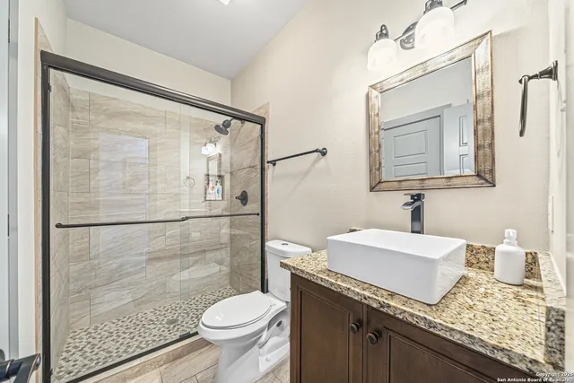 a bathroom with a granite countertop sink toilet and shower