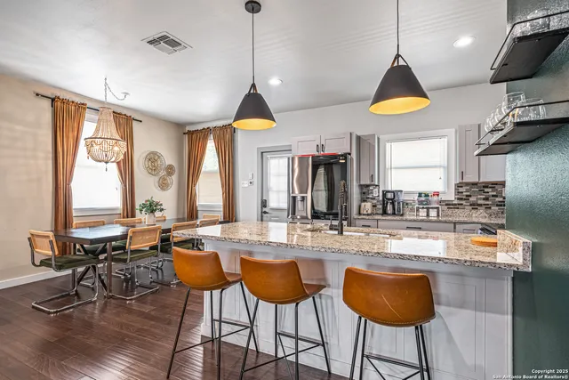 a view of a kitchen with stainless steel appliances granite countertop a dining table and chairs