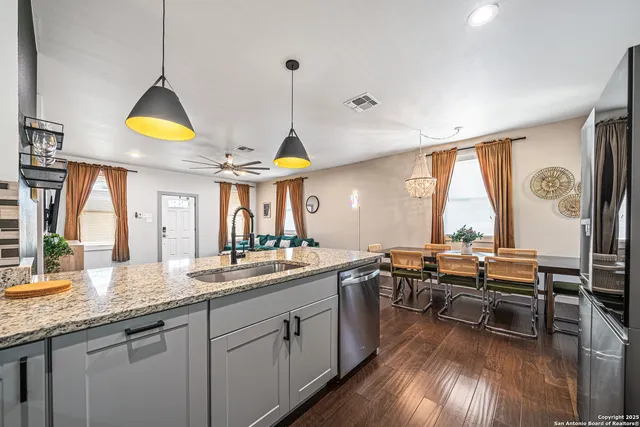 a kitchen with stainless steel appliances granite countertop a stove a sink and a wooden floors