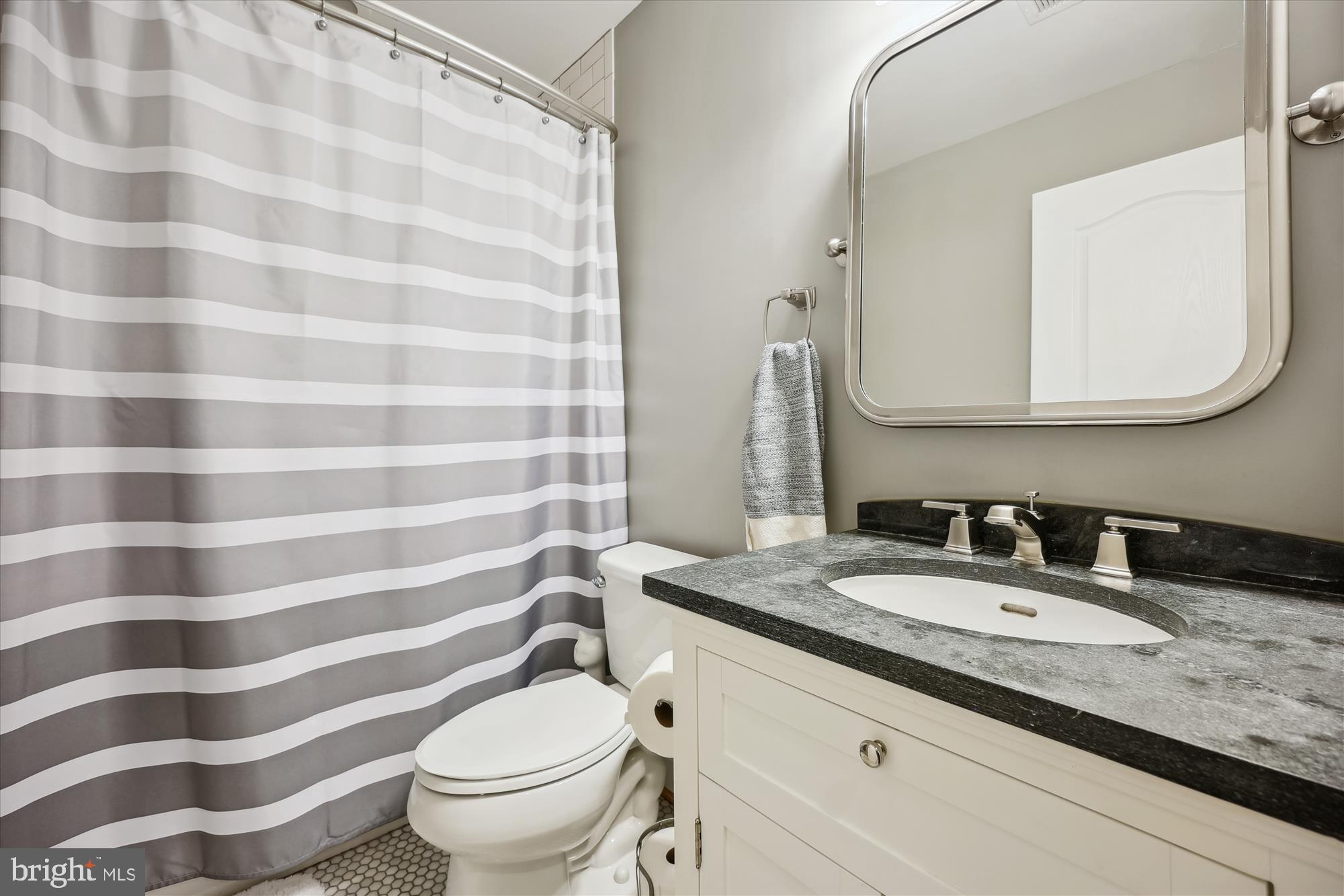 8103 Piney Branch Road Silver Spring, MD 20910 - Photo 14 of 42 a bathroom with a granite countertop sink a toilet and a mirror