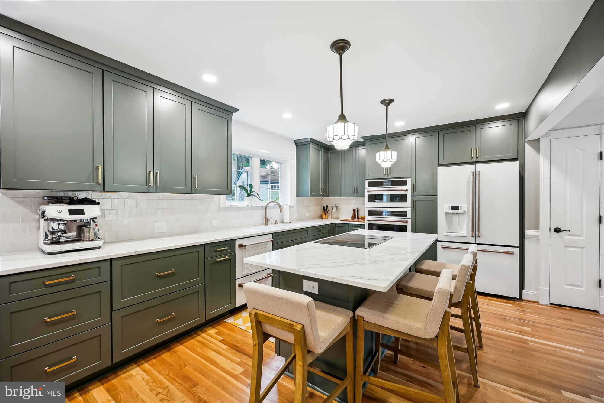 8103 Piney Branch Road Silver Spring, MD 20910 - Photo 6 of 42 a kitchen with stainless steel appliances kitchen island granite countertop a table chairs in it and wooden floors