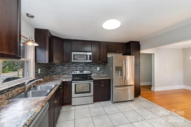 a kitchen with granite countertop a refrigerator and a sink