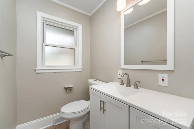 a bathroom with a toilet sink vanity and mirror