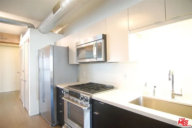a kitchen with kitchen island sink and refrigerator