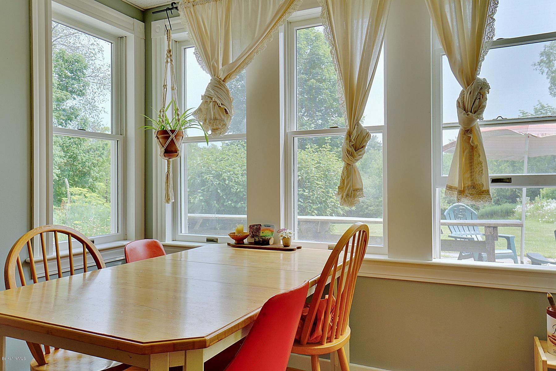 200 Main Road Monterey, MA 01245 - Photo 26 of 30 a dining room with furniture a chandelier and wooden floor