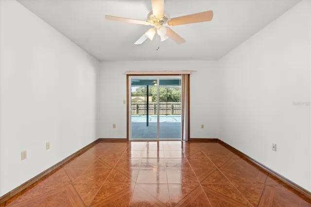 an empty room with chandelier fan