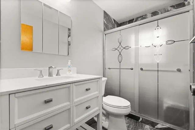 a bathroom with a sink a toilet and shower