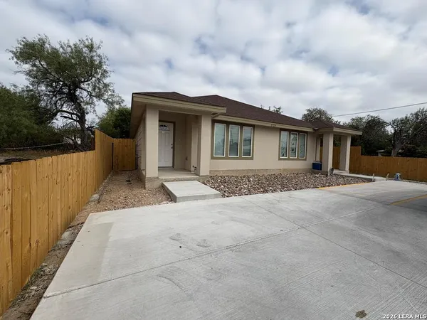 a front view of a house with a yard and trees