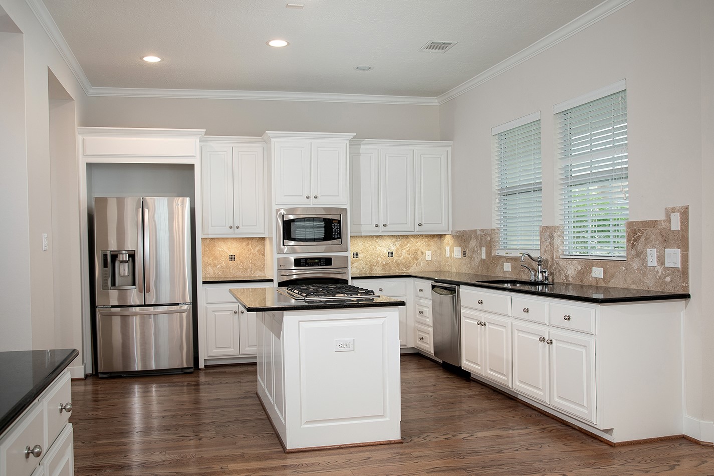 190 West Breezy Way Spring, TX 77380 - Photo 19 of 33 This modern kitchen features sleek stainless steel appliances, white cabinetry, and granite countertops. Ideal for cooking and entertaining.