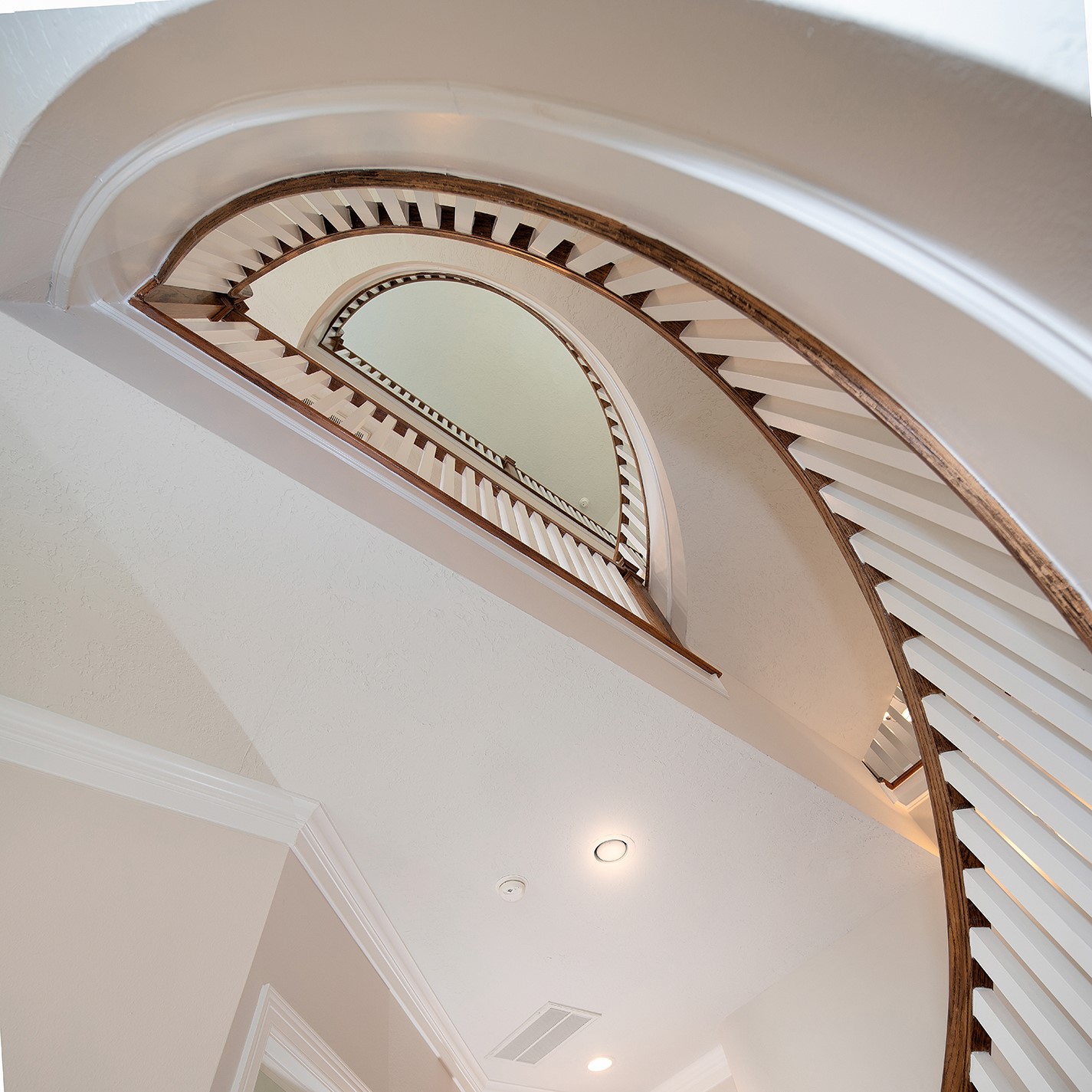 190 West Breezy Way Spring, TX 77380 - Photo 6 of 33 The stunning spiral staircase with elegant wood detailing and white balusters, creates a sophisticated focal point in the home's interior.