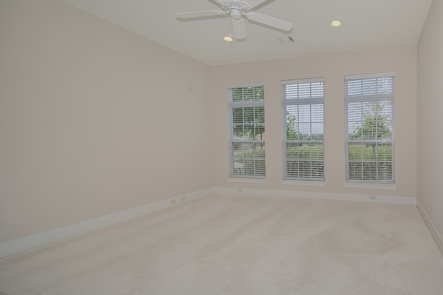 190 West Breezy Way Spring, TX 77380 - Photo 7 of 33 Bright room with large windows featuring white blinds, neutral walls and carpet, ceiling fan, and recessed lighting. Ideal for a cozy bedroom or office space.