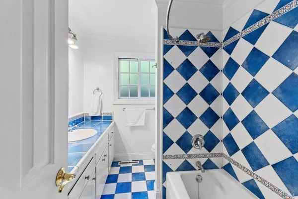 a kitchen with a checkered floor and white cabinets