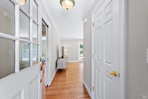 a view of a hallway with wooden floor and staircase
