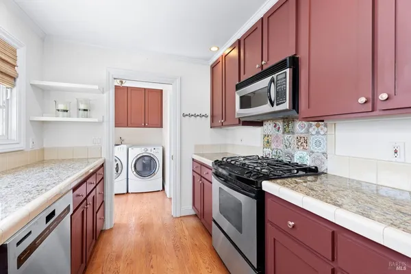 a kitchen with granite countertop a sink stove and cabinets