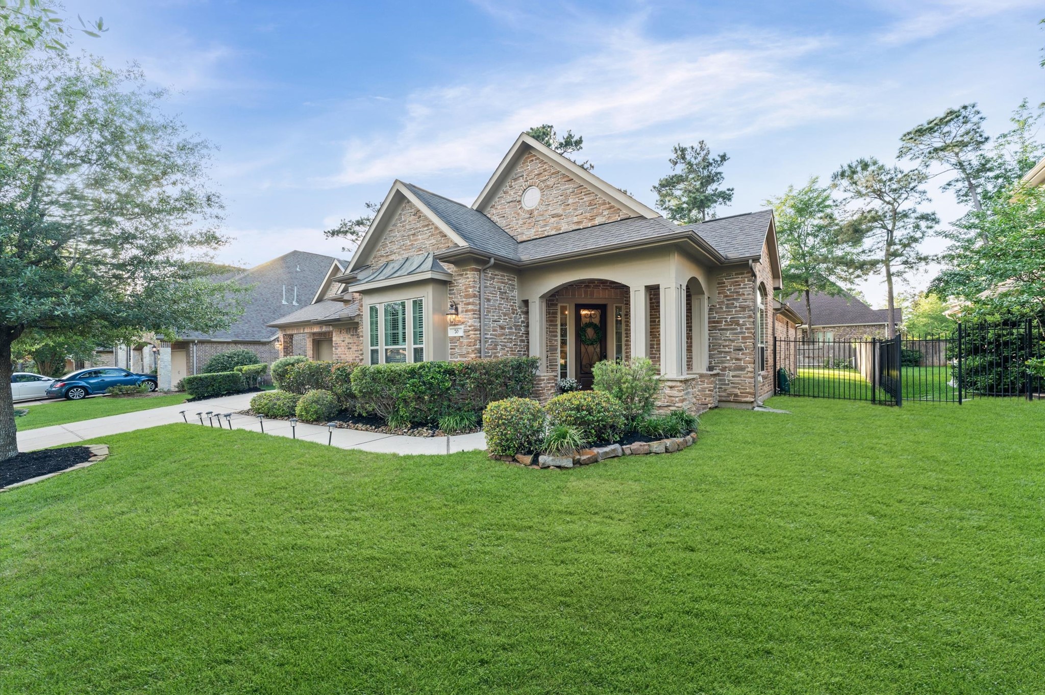 70 Valera Ridge Drive Spring, TX 77389 - Photo 3 of 37 Charming stone and brick home with a manicured lawn, inviting front porch, and lush landscaping. Located in a serene neighborhood with mature trees, offering privacy and a welcoming atmosphere.