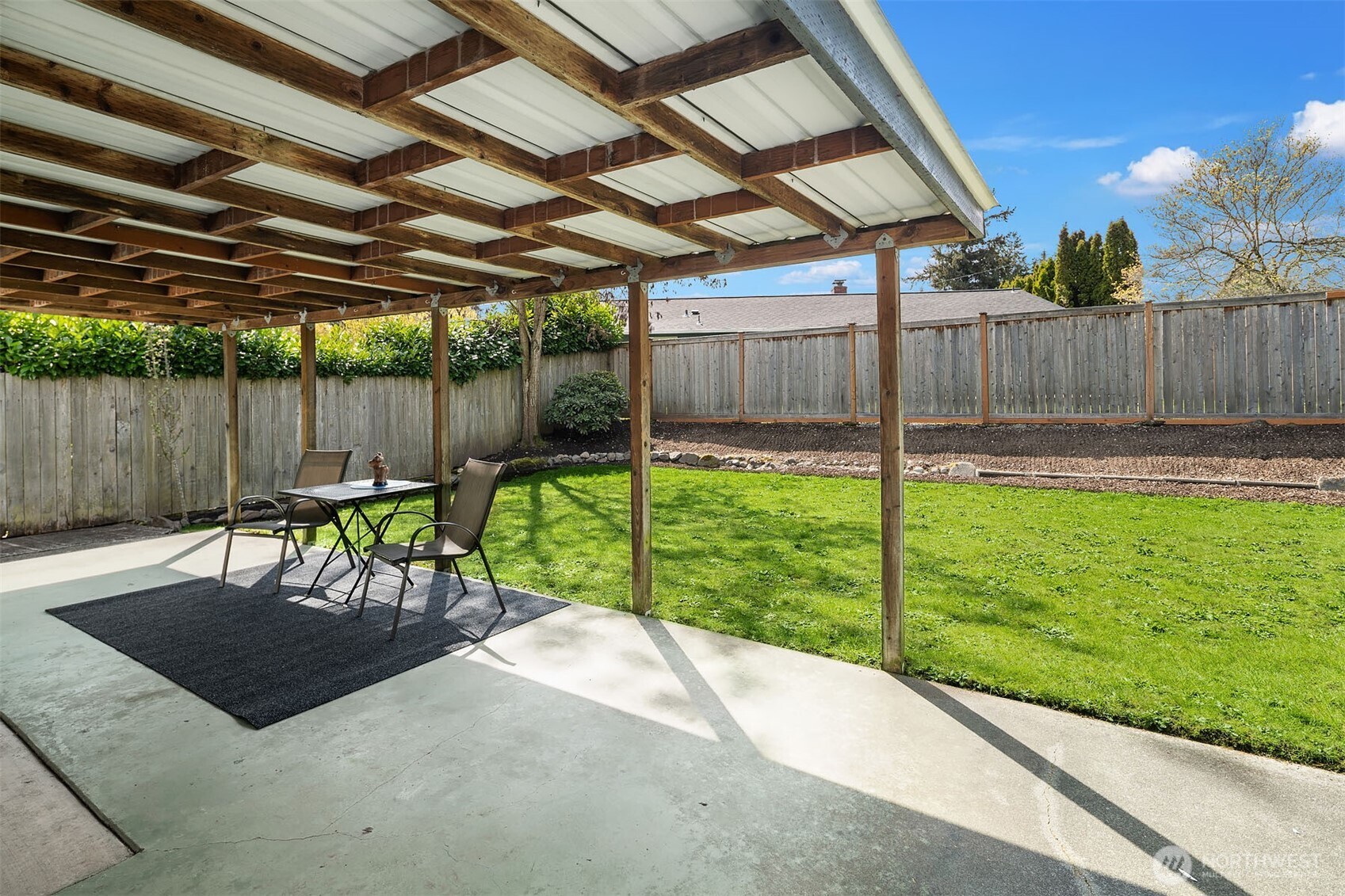 1067 Anacortes Avenue Northeast Renton, WA 98059 - Photo 23 of 34 a view of a backyard with table and chairs with wooden fence
