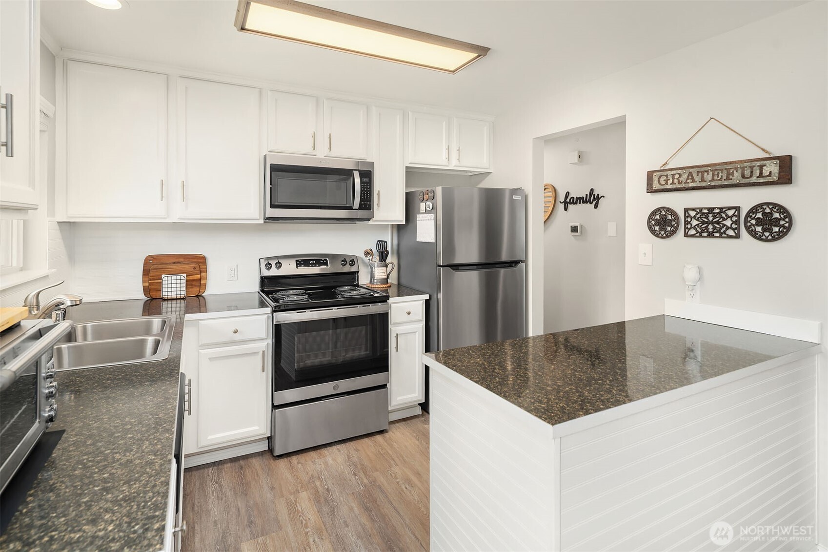 1067 Anacortes Avenue Northeast Renton, WA 98059 - Photo 8 of 34 a kitchen with granite countertop a refrigerator stove and microwave
