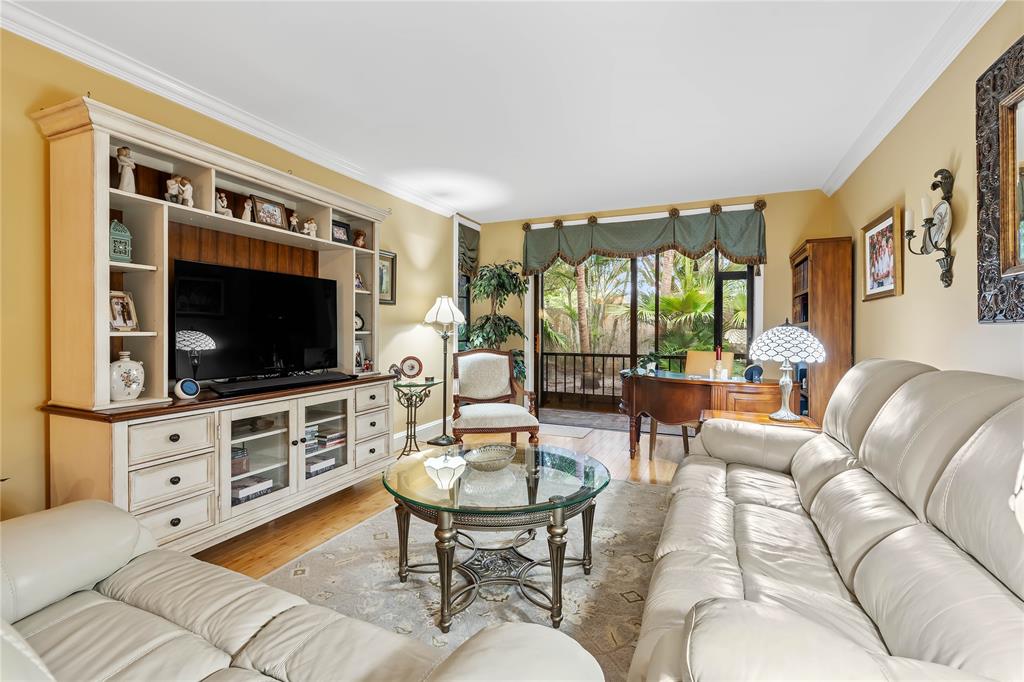 7970 La Mirada Drive, Unit 20 Boca Raton, FL 33433 - Photo 17 of 38 a living room with furniture a flat screen tv and a large window