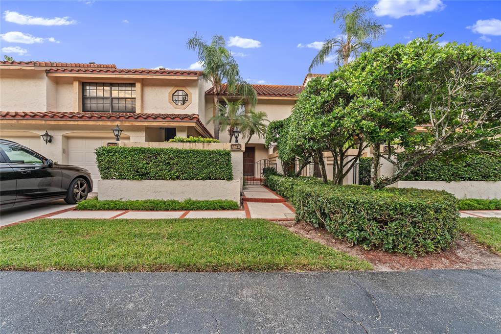 7970 La Mirada Drive, Unit 20 Boca Raton, FL 33433 - Photo 5 of 38 a front view of a house with a yard and garage