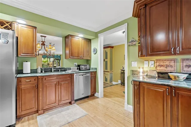 a kitchen with granite countertop stainless steel appliances a counter top space and cabinets