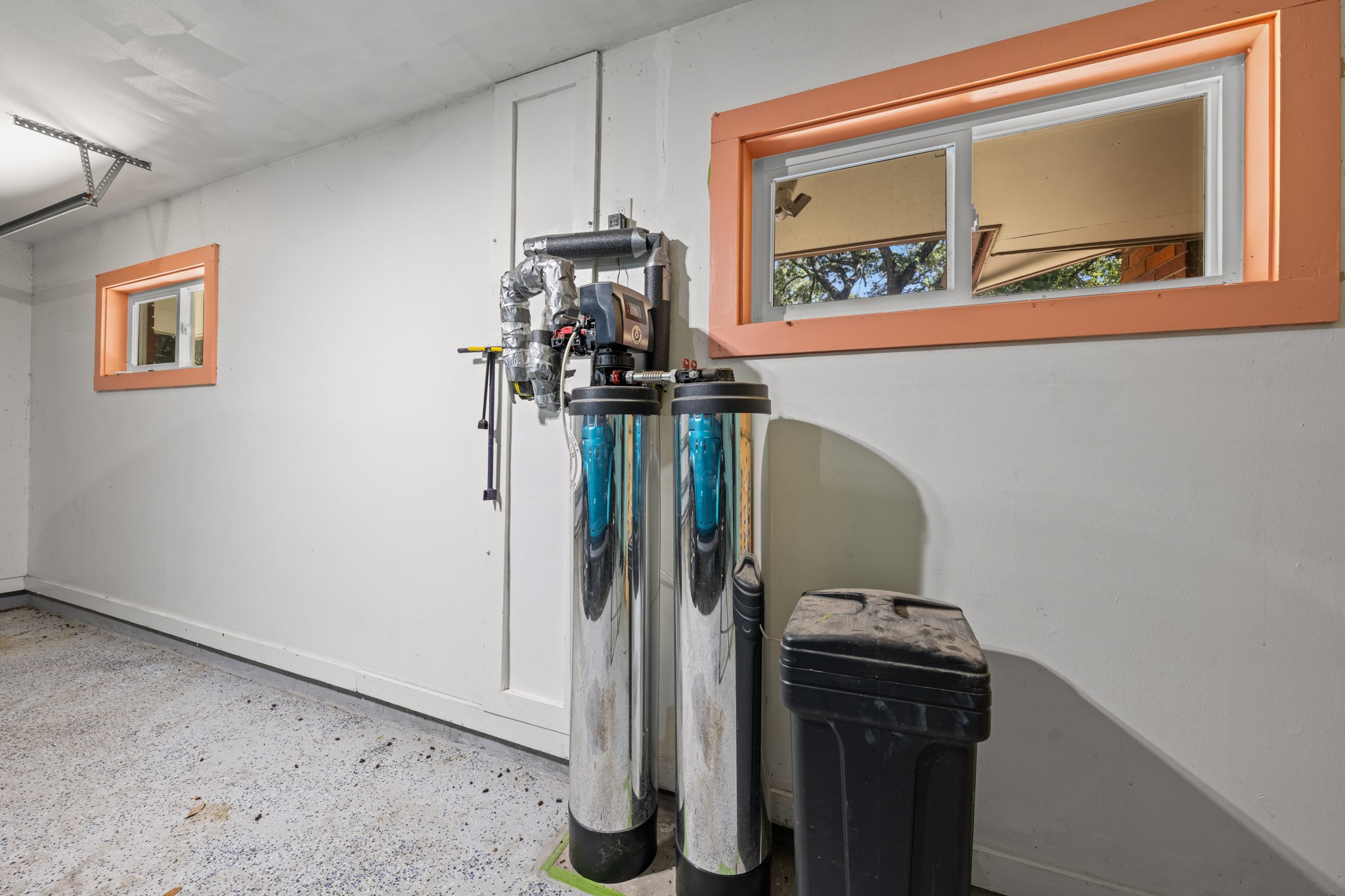 616 Cannan Drive Angleton, TX 77515 - Photo 28 of 49 The garage utility area includes additional storage space and a whole-home water treatment system, enhancing both convenience and functionality. Thoughtfully equipped utility features support the home's day-to-day efficiency while providing valuable infrastructure upgrades.