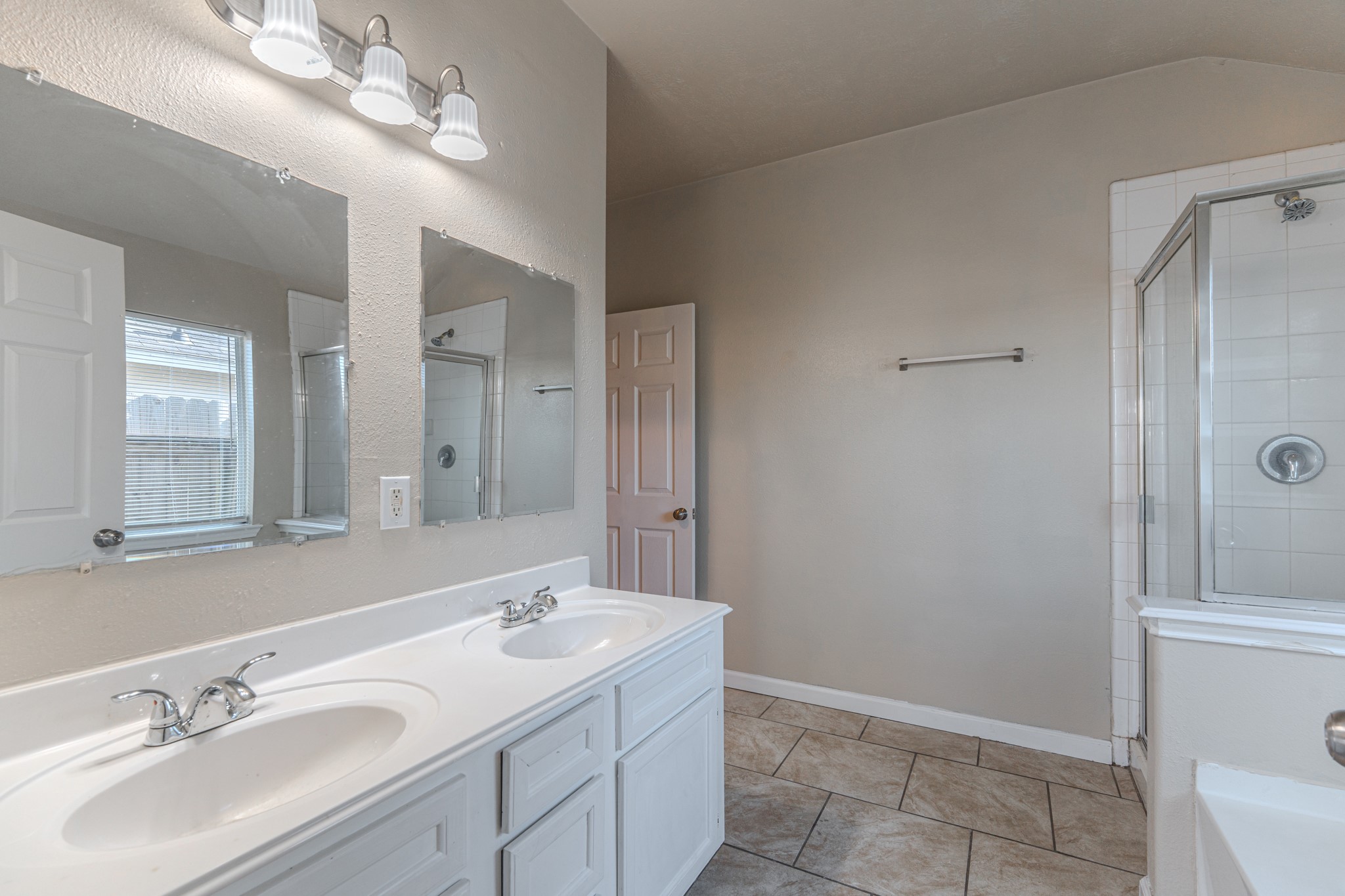 3619 Fiorella Way Humble, TX 77338 - Photo 11 of 16 This bathroom features a clean, white aesthetic with a tiled shower-bathtub combo, a large vanity mirror, and a single sink. The space is well-lit with overhead lighting, creating a bright and inviting atmosphere.
