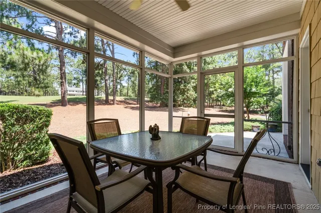 a view of a brick house with a yard plants and large tree