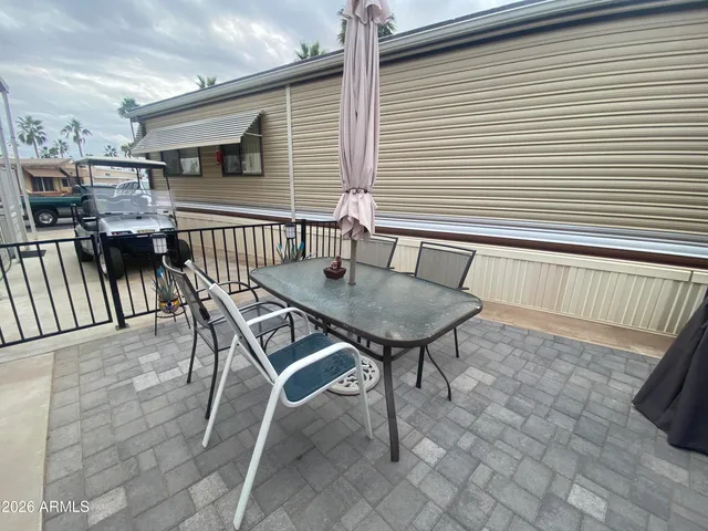 a view of a patio with table and chairs a barbeque with wooden floor and roof