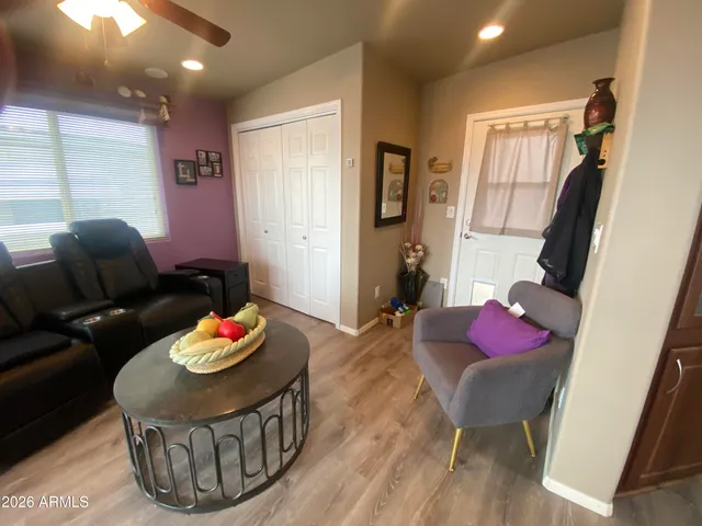 a view of a dining room with furniture a kitchen and wooden floor