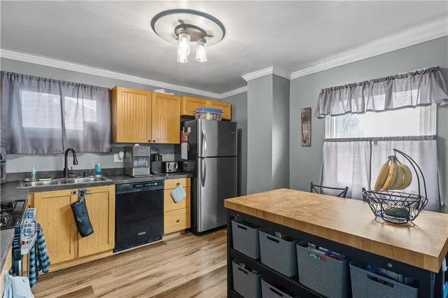 a kitchen with kitchen island granite countertop a sink cabinets and stainless steel appliances