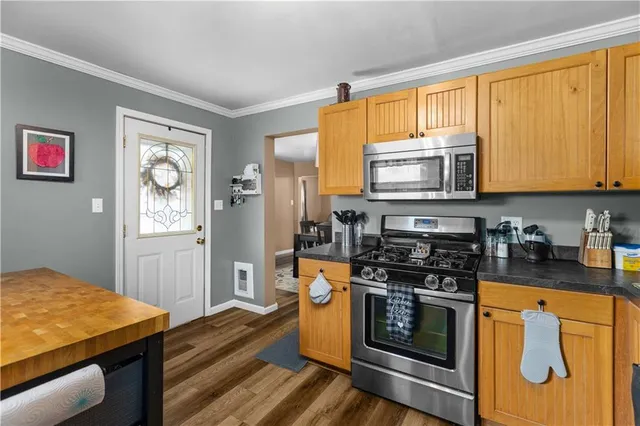 a kitchen with stainless steel appliances granite countertop a stove a sink and a microwave