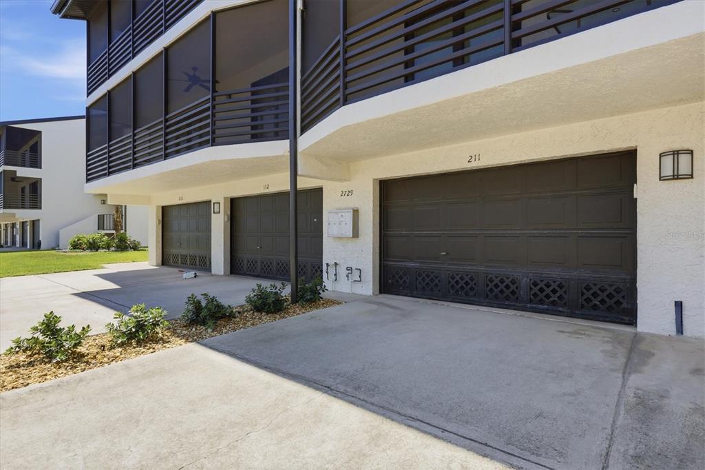2729 North Beach Road, Unit 211 Englewood, FL 34223 - Photo 36 of 51 a front view of a house with a yard and garage