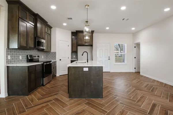a kitchen with granite countertop a refrigerator stove top oven and sink