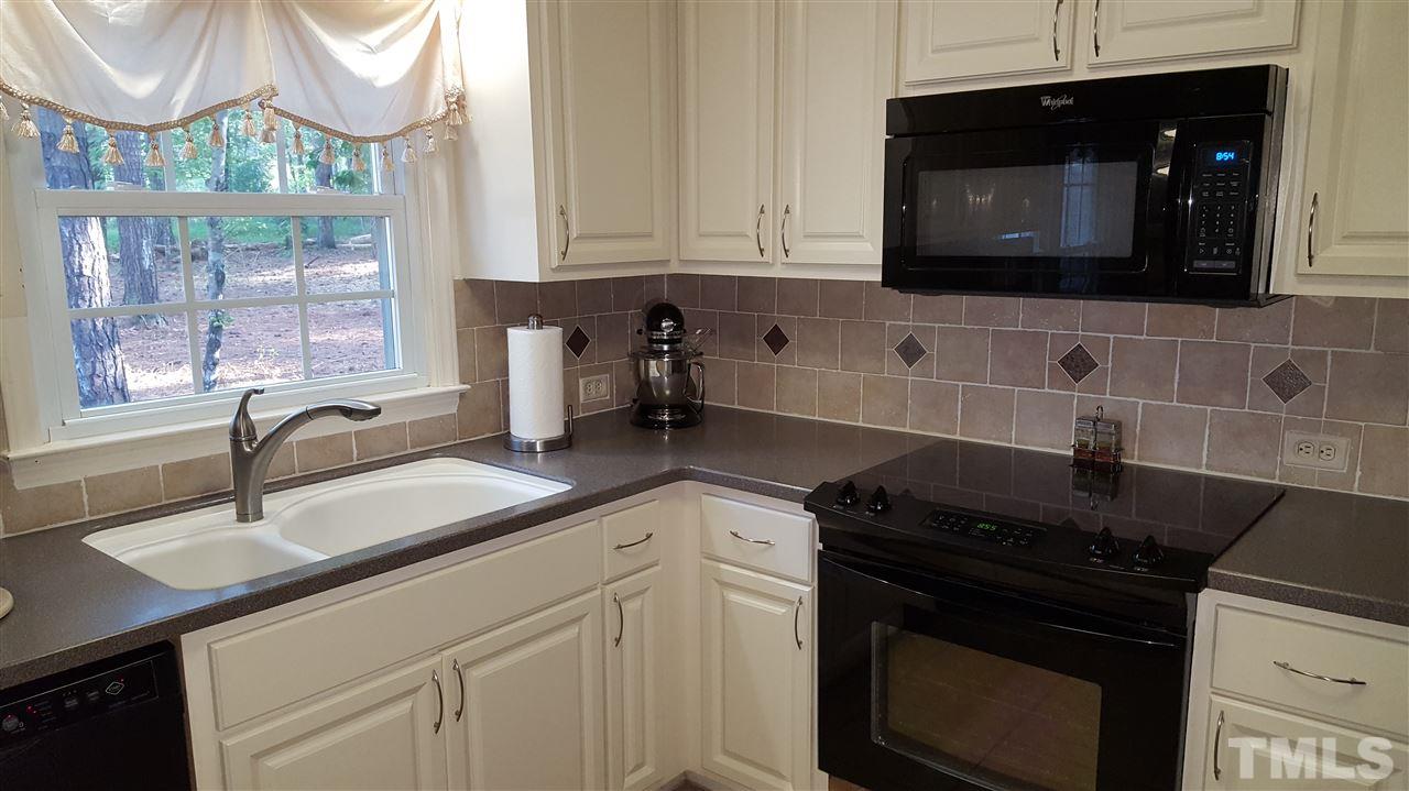 1113 Hamilton Way Durham, NC 27713 - Photo 12 of 25 a kitchen with stainless steel appliances granite countertop a sink a stove a microwave and wooden cabinets