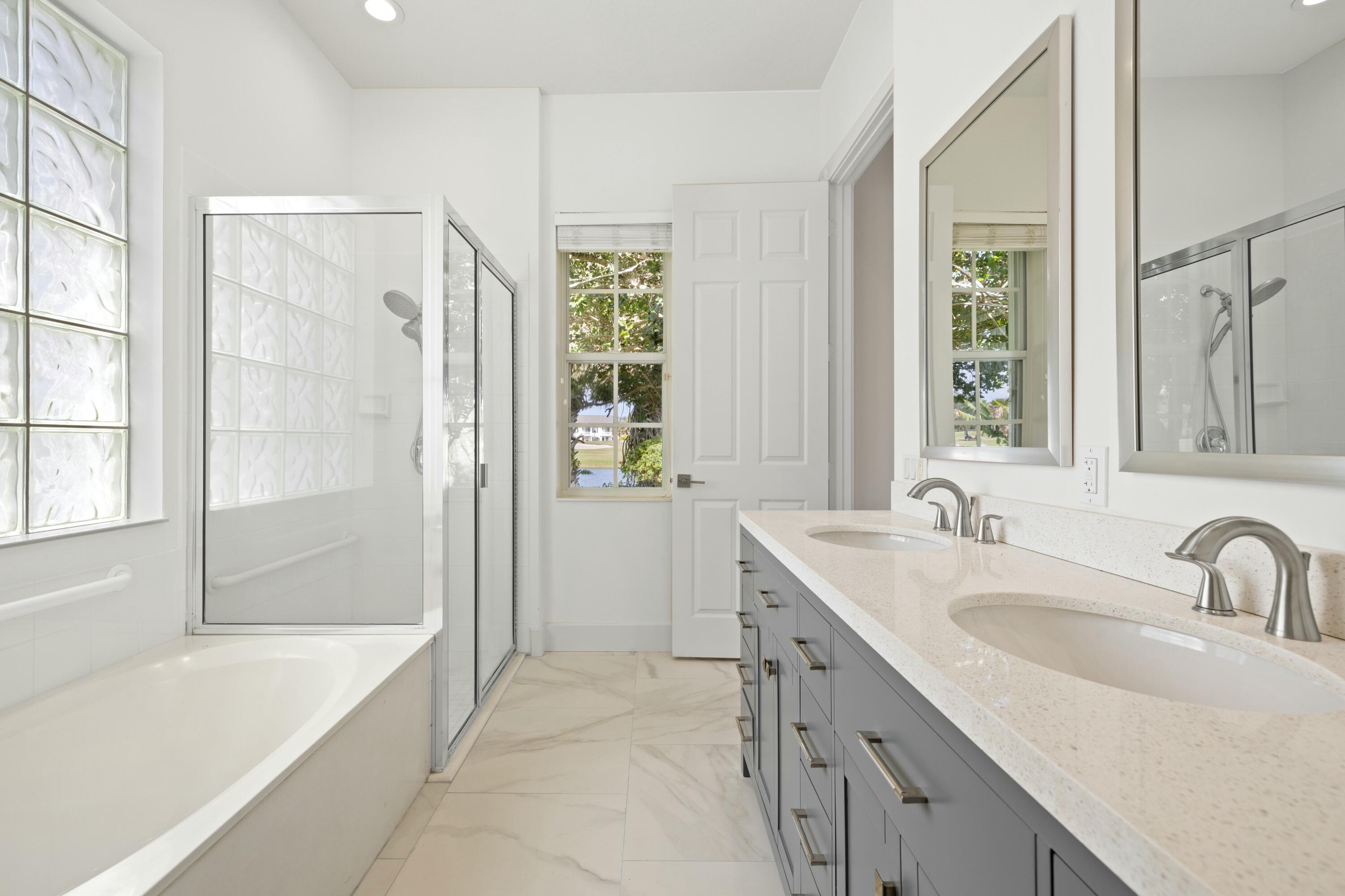 140 Barbados Drive Jupiter, FL 33458 - Photo 14 of 42 a bathroom with a tub sink and mirror