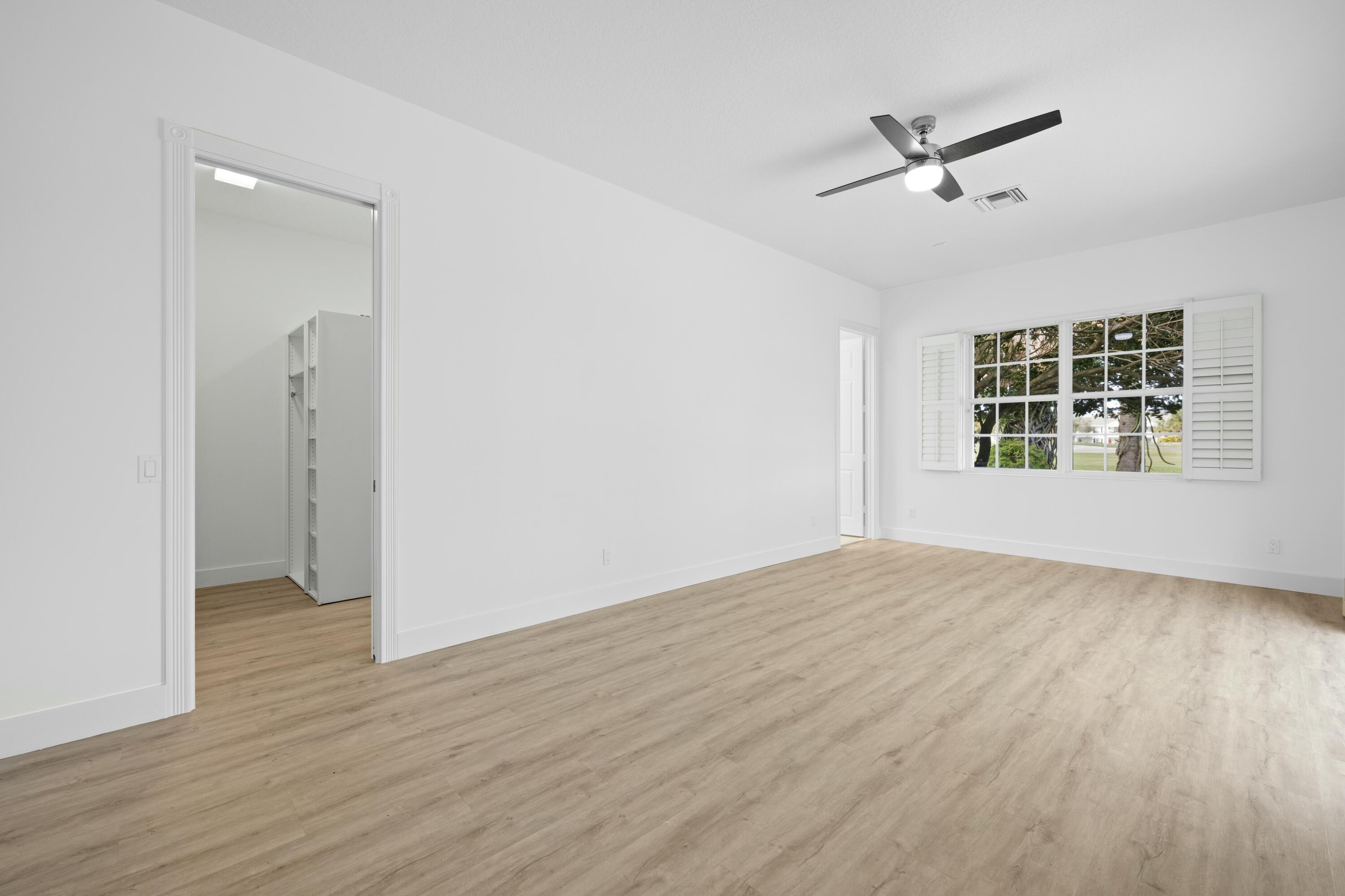 140 Barbados Drive Jupiter, FL 33458 - Photo 17 of 42 an empty room with wooden floor chandelier and windows