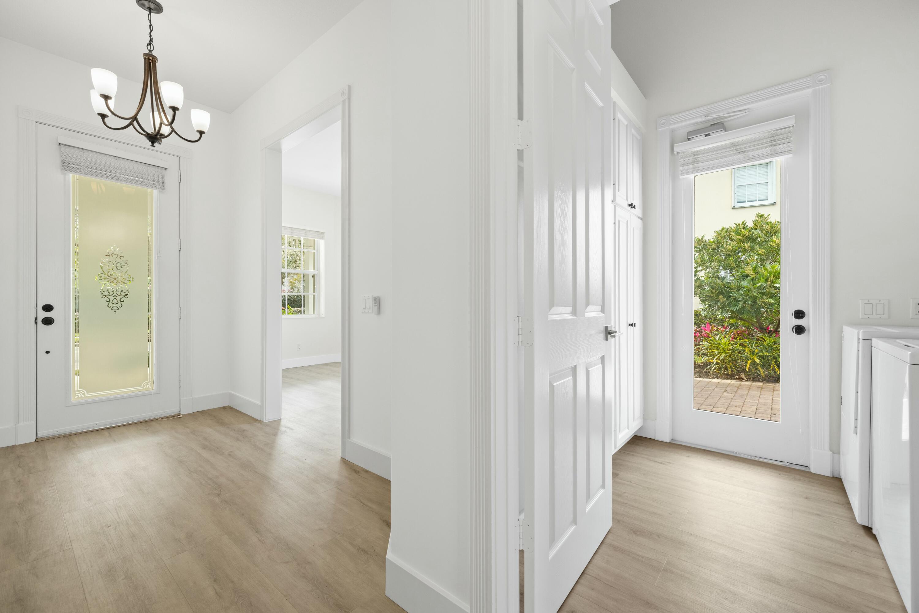 140 Barbados Drive Jupiter, FL 33458 - Photo 22 of 42 a view of a hallway with wooden floor and a chandelier