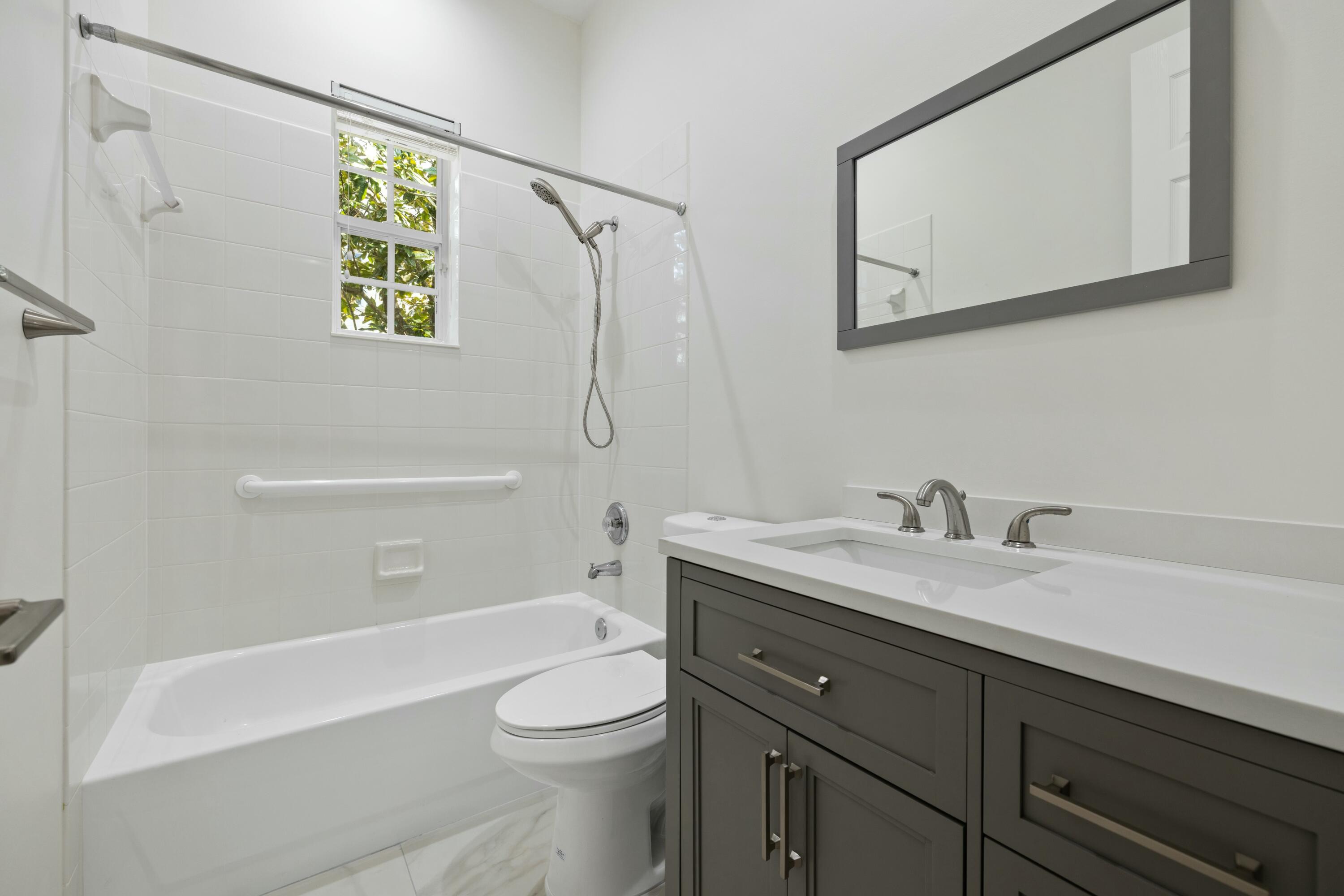 140 Barbados Drive Jupiter, FL 33458 - Photo 24 of 42 a bathroom with a granite countertop sink a toilet and shower