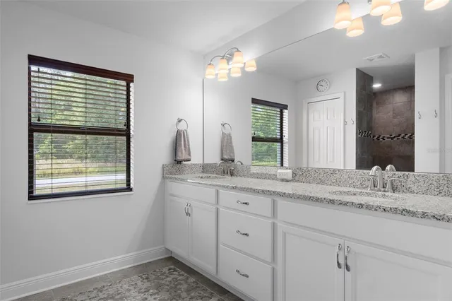 a bathroom with a granite countertop sink vanity and a mirror