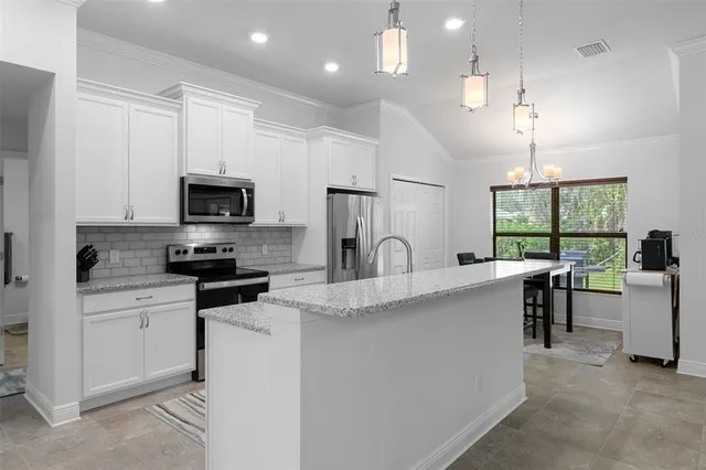 a kitchen with center island table and chairs