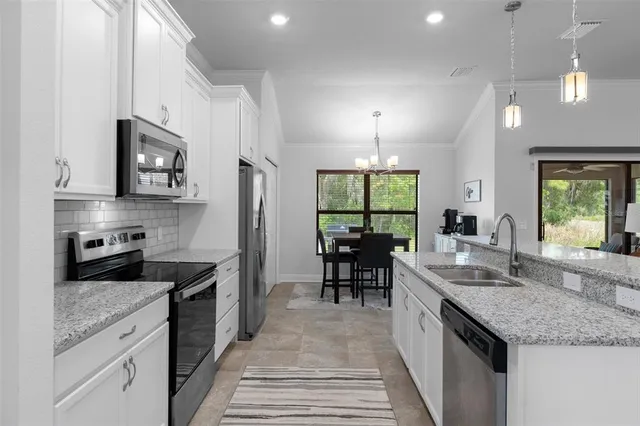 a kitchen with stainless steel appliances a stove sink microwave and refrigerator