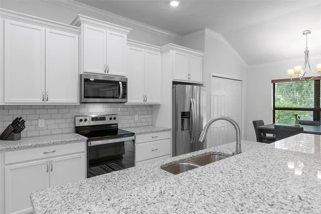 a kitchen with white cabinets and stainless steel appliances