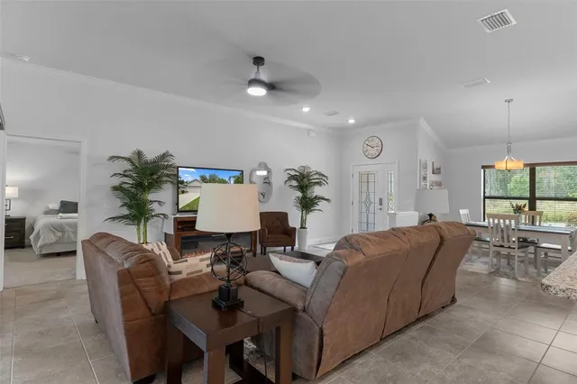 a living room with furniture a large window and a chandelier