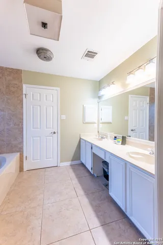 a large bathroom with a large tub shower and sink