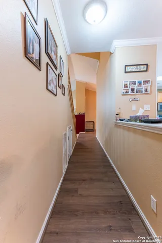 a hallway with wooden floor and stairs