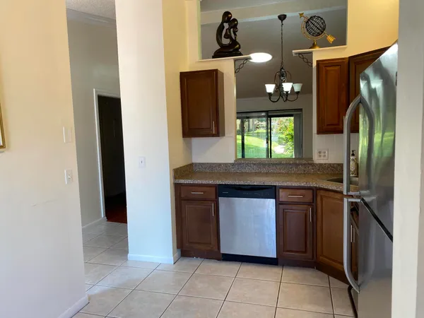 a kitchen with stainless steel appliances granite countertop a sink and a refrigerator
