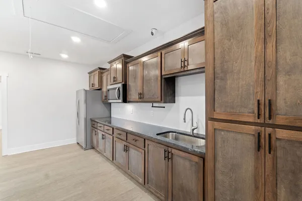 a kitchen with stainless steel appliances granite countertop a refrigerator and a sink