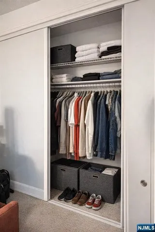 a view of walk in closet with clothes and shoes