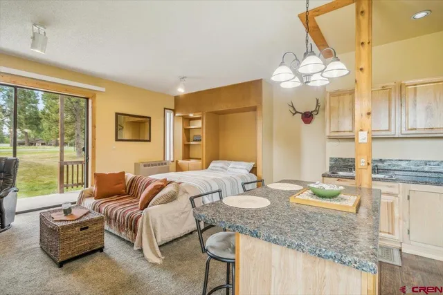 a spacious bedroom with a bed and a chandelier